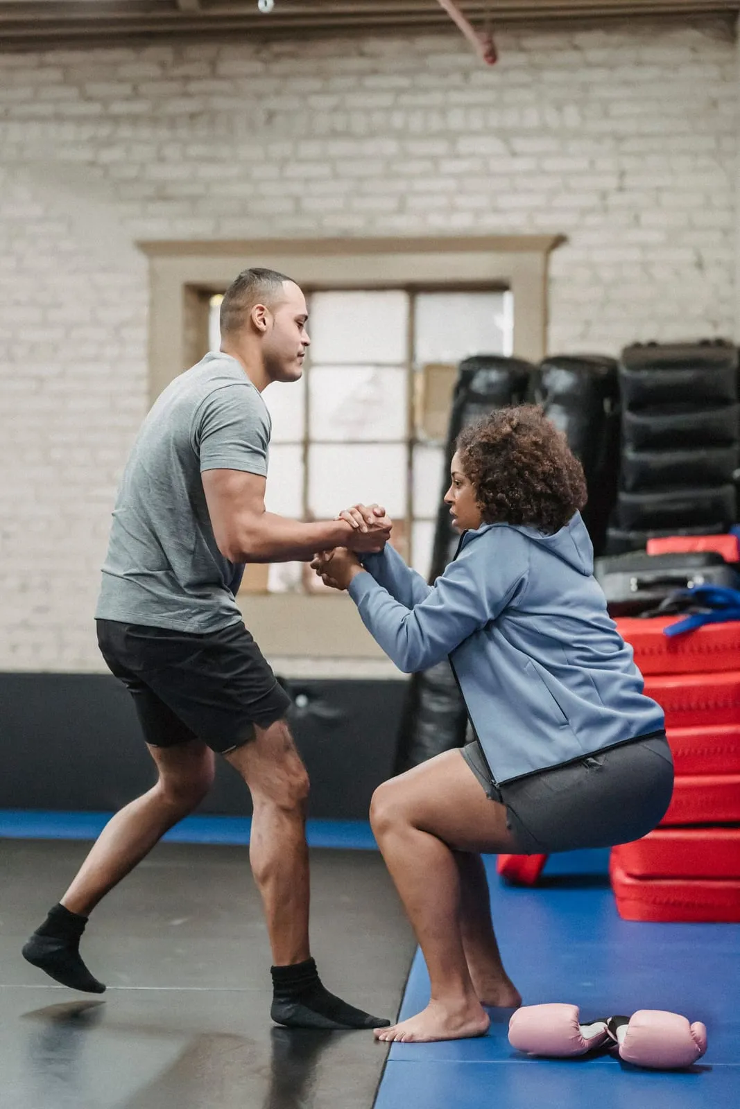 Trainer helping Anjana up from the floor at the end of a session