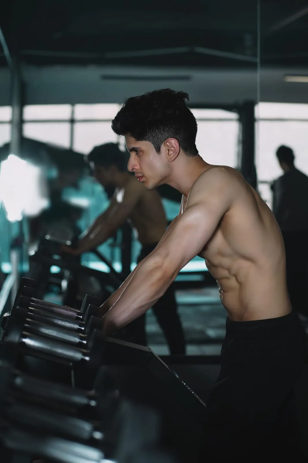 Bibek picking up dumbbells from the rack
