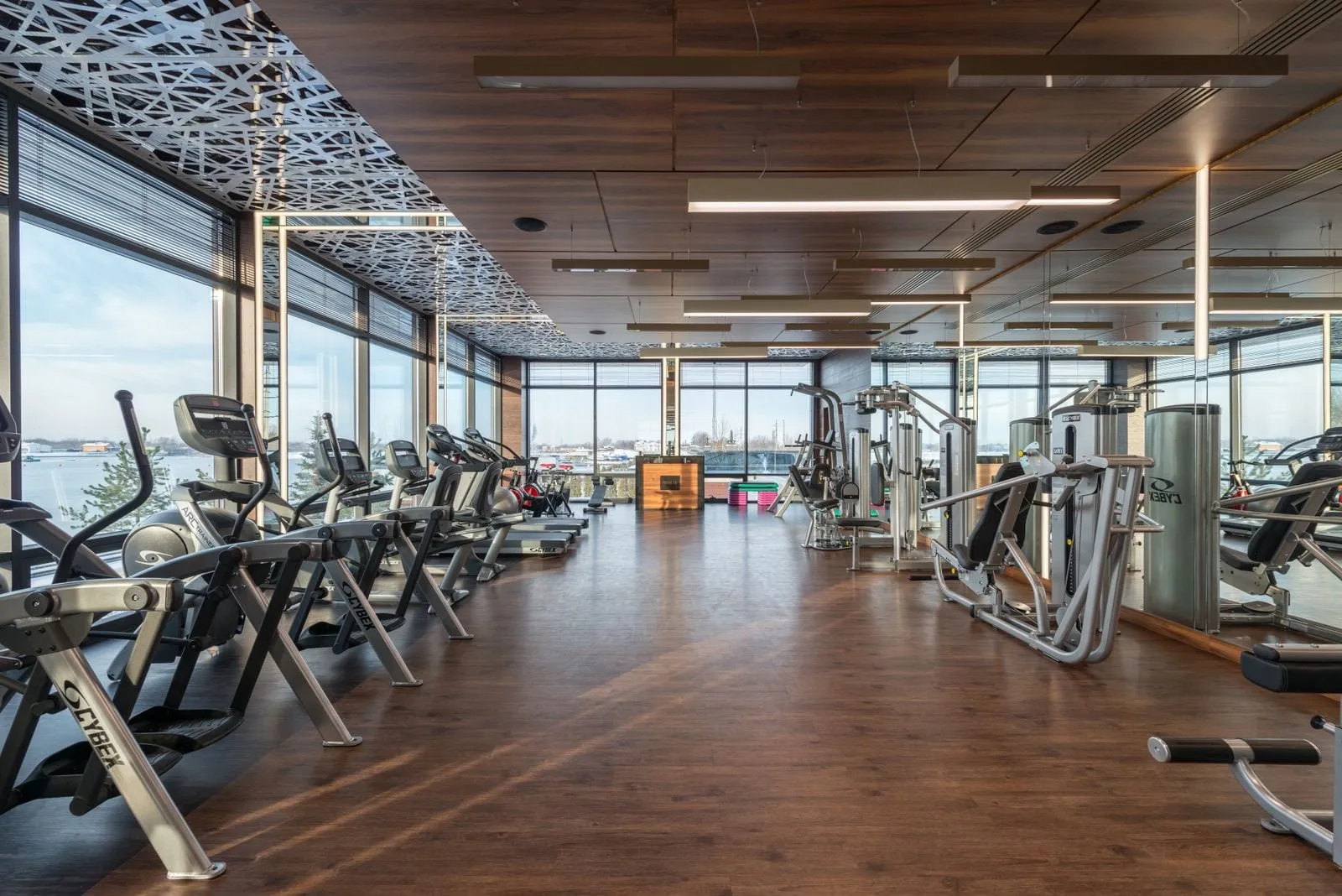 Spacious gym floor with wooden flooring and tall windows