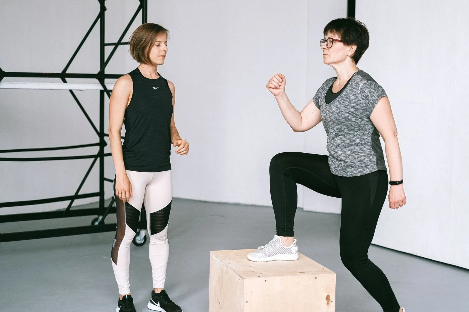 Helen stepping onto a box while her trainer demonstrates