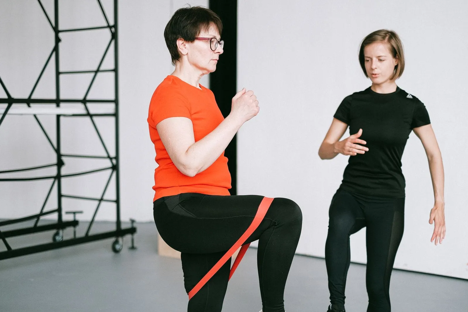 Helen doing a resistance band exercise beside her trainer