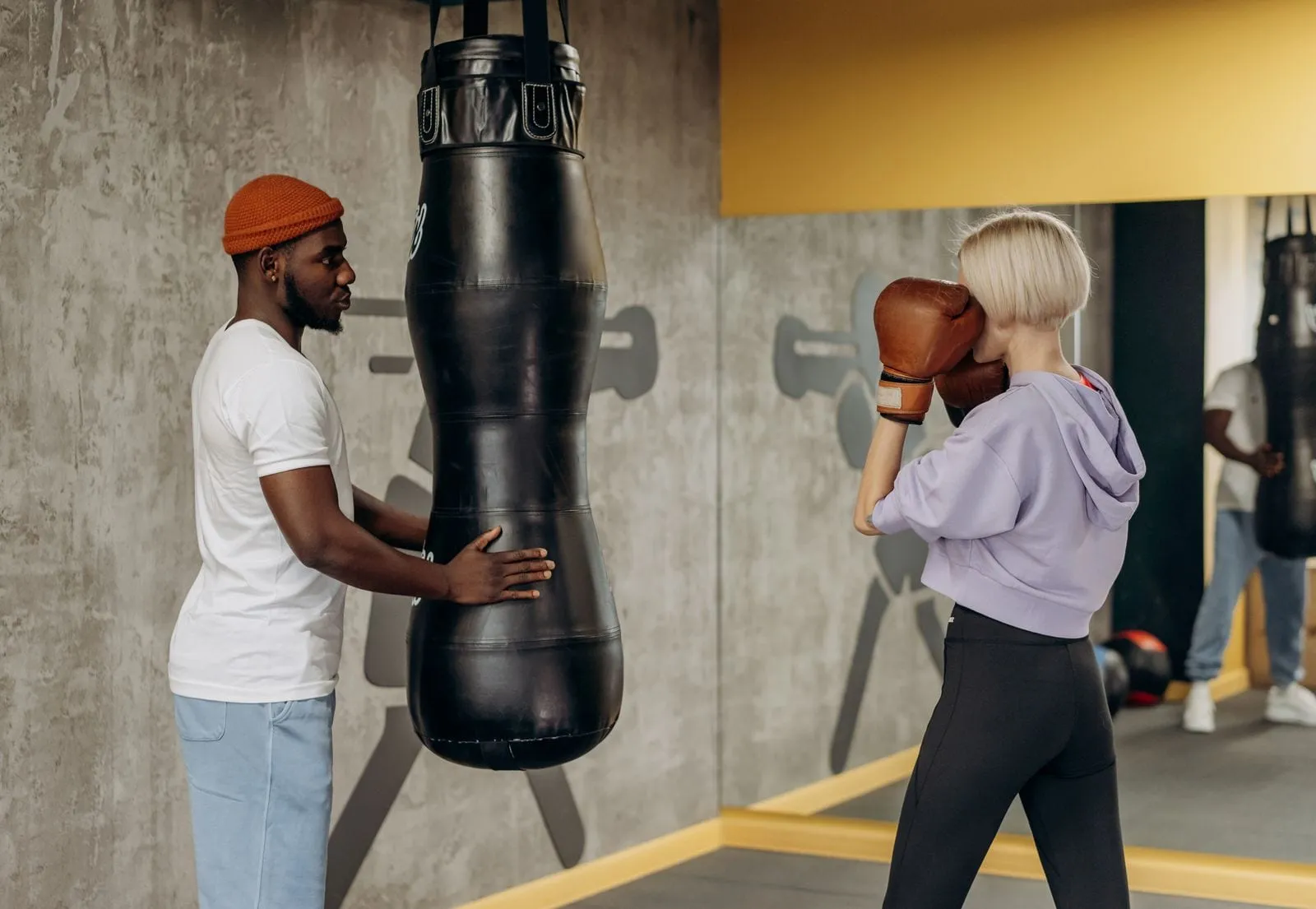 Lena throwing a jab at the heavy bag as her coach watches