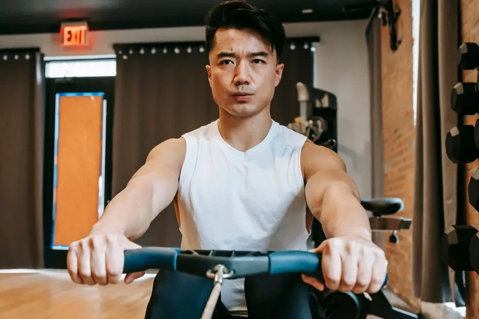 A man training hard on a rowing machine in a gym