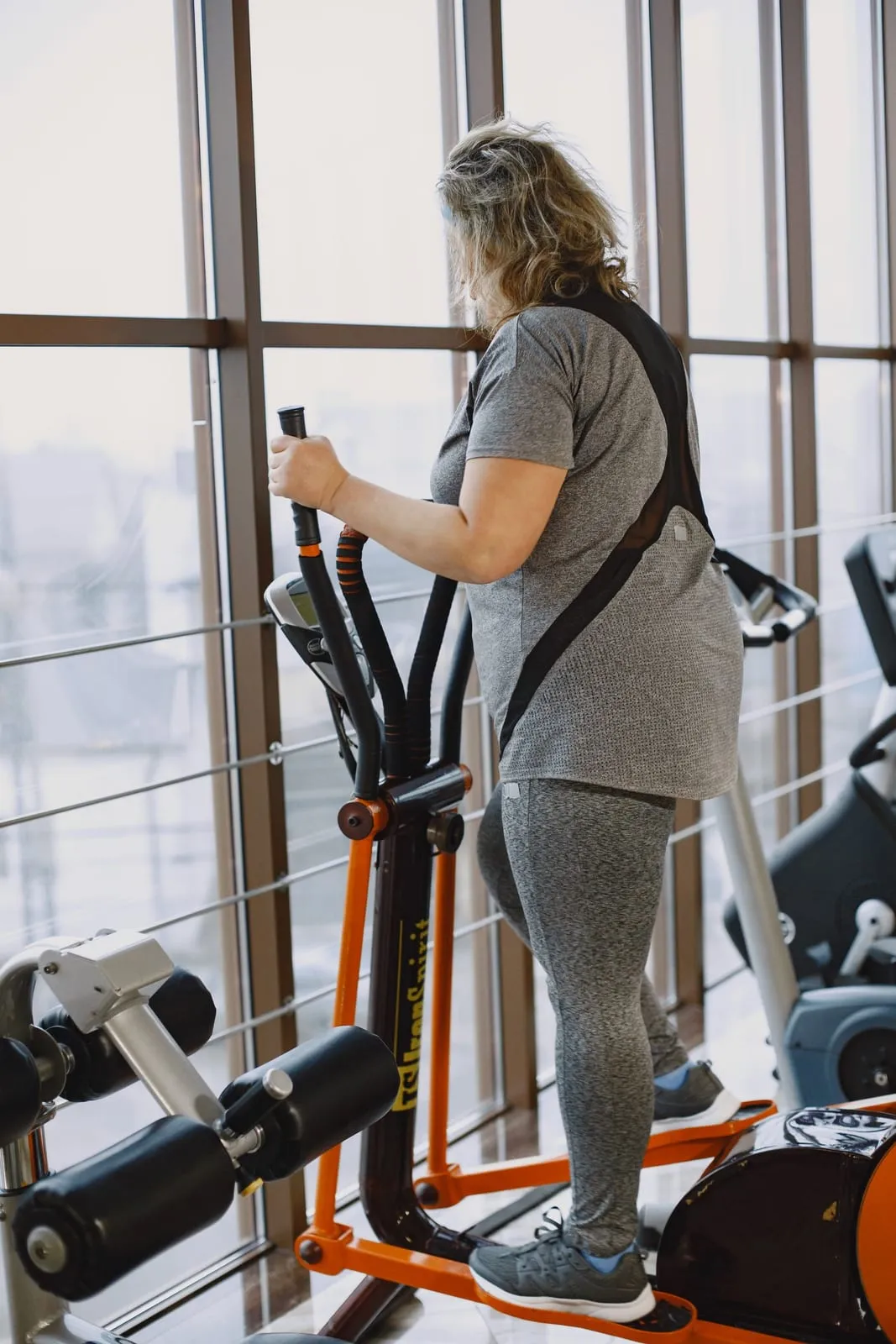 Maya working on a stair climber, seen from the side