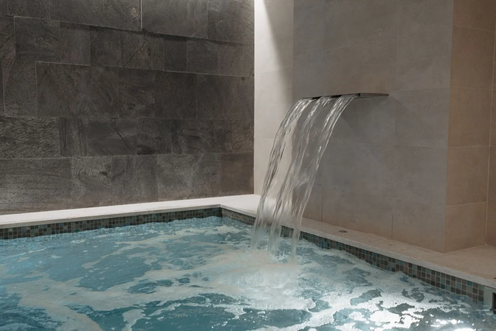 Stone plunge pool with a waterfall spout