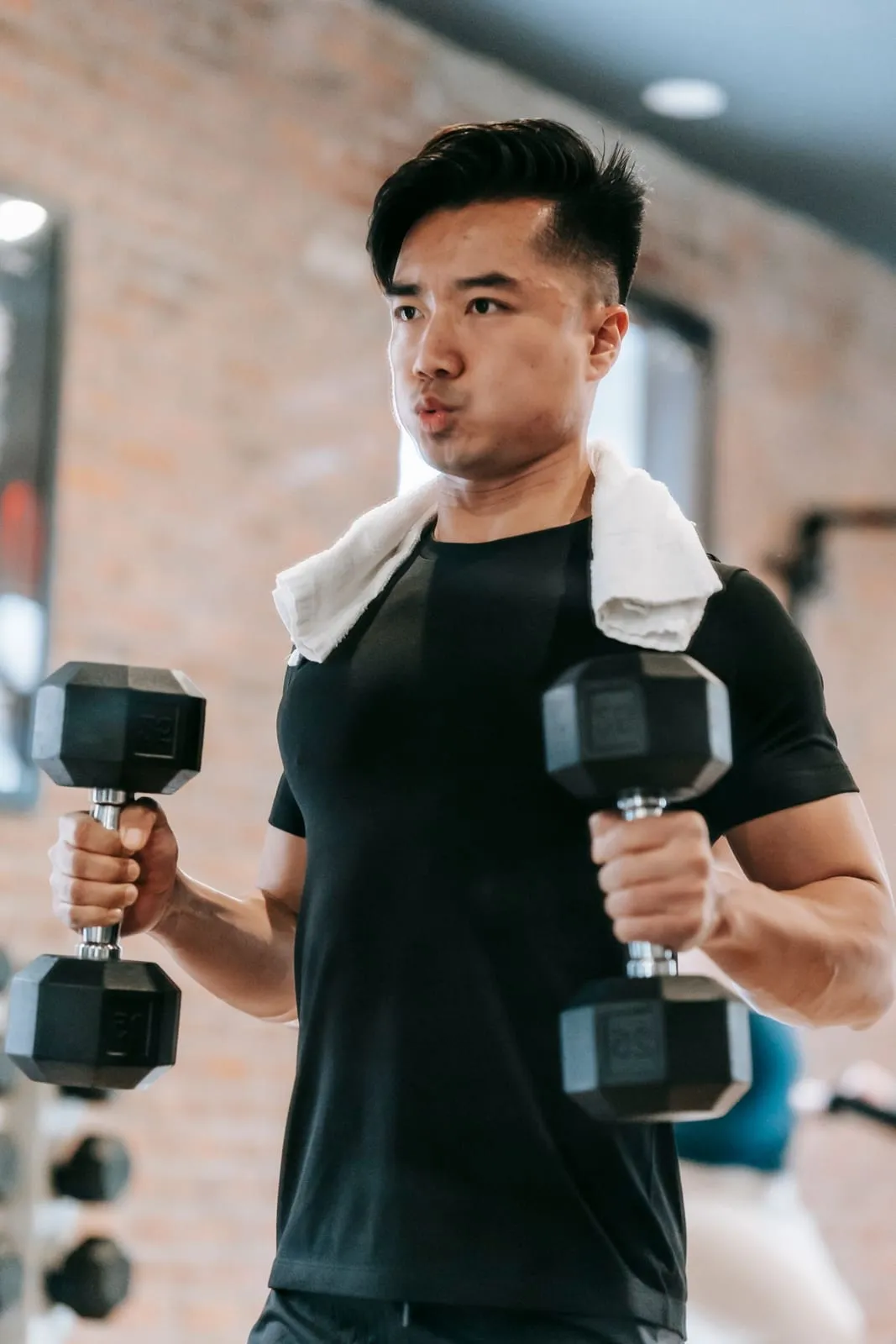 Rohan training with dumbbells, a towel over his shoulders