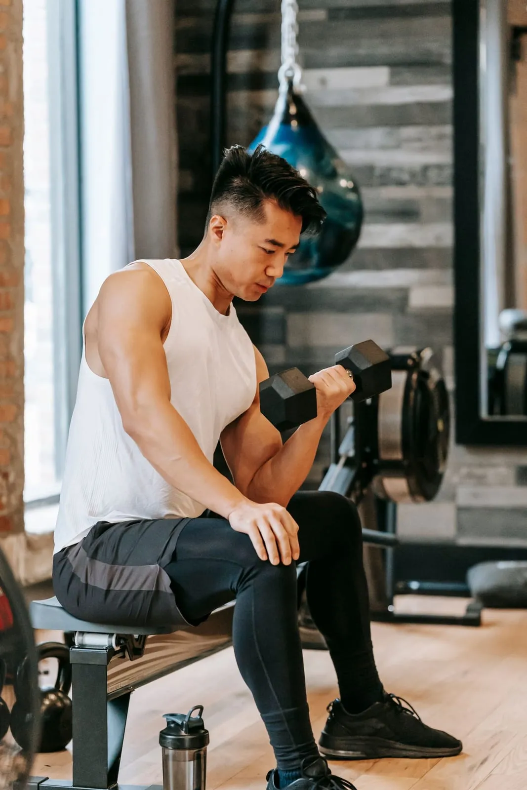 Rohan doing seated dumbbell curls on a bench