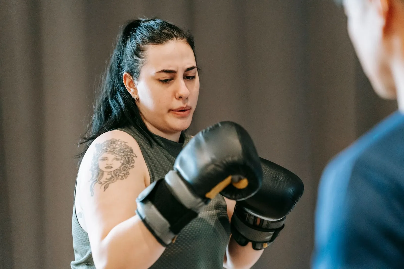 Sunita in boxing gloves, concentrating, ready to hit pads