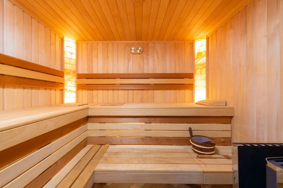 An empty wooden sauna with tiered benches and warm lighting